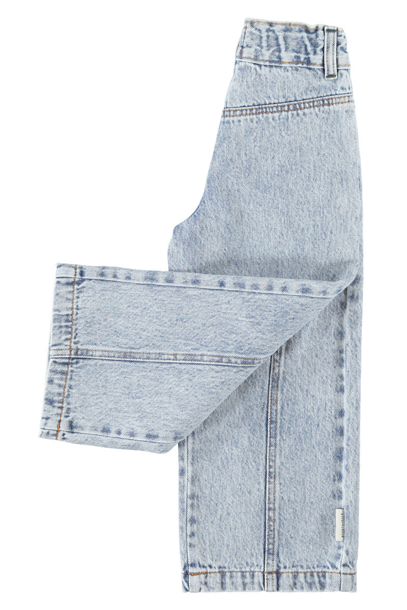 Detalle de pantalón acampanado de niña azul claro con denim lavado de piupiuchick.