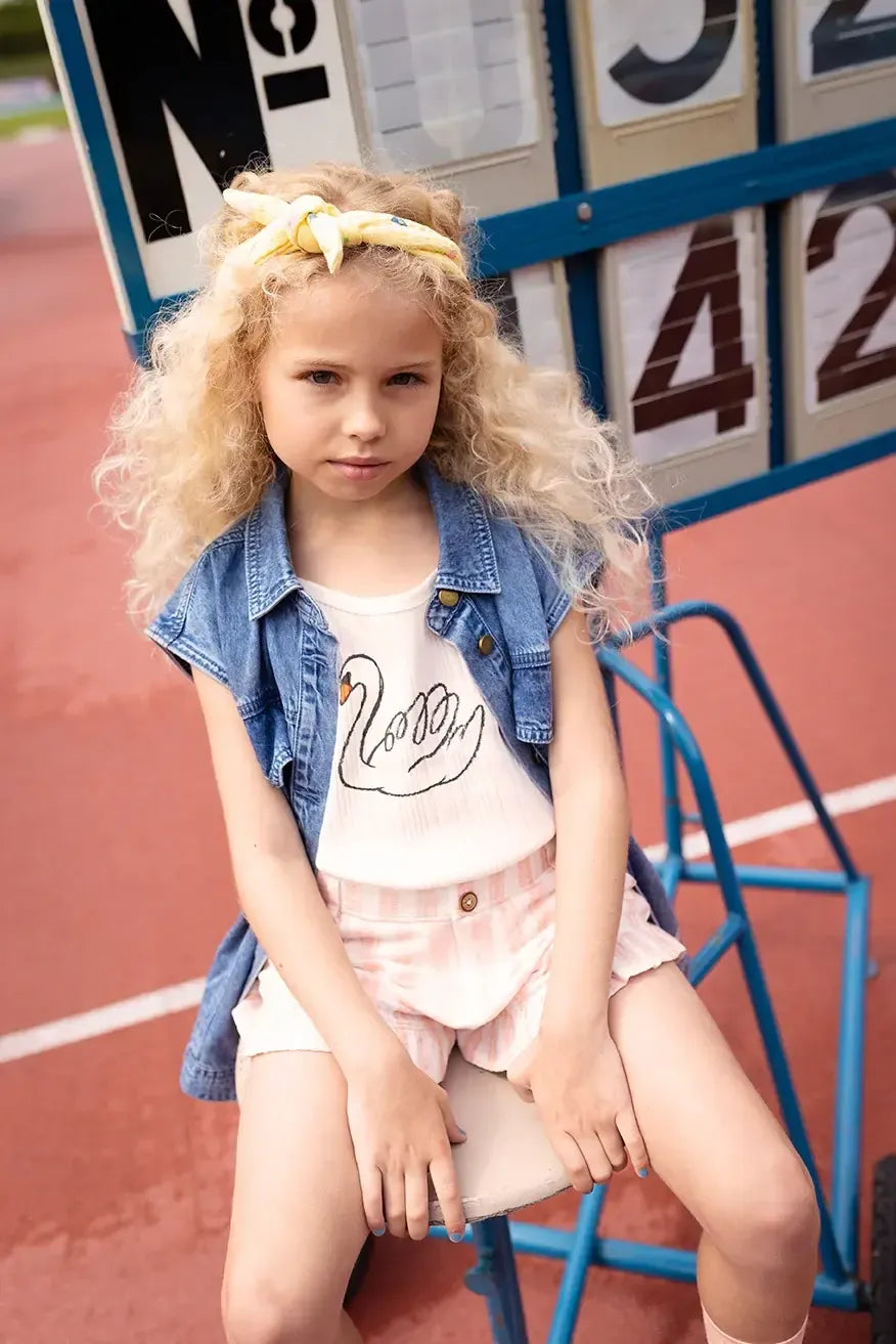 Niña con camiseta cruda de tirantes y motivo de cisne de Sproet & Sprout.