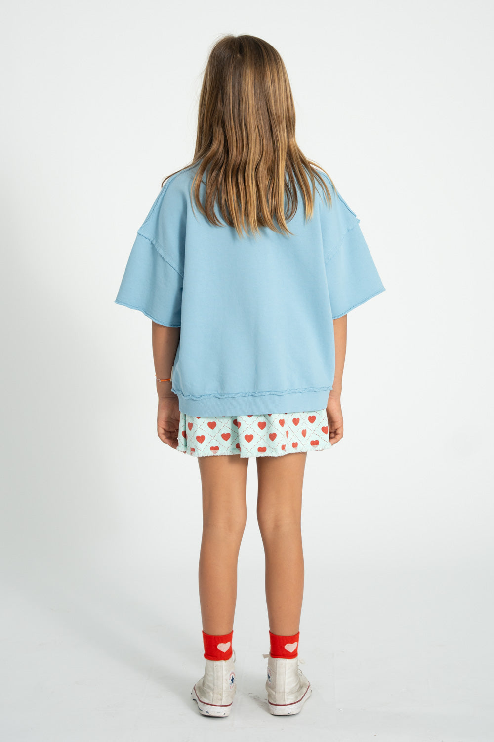 Falda corta azul claro con estampado de corazones rojos por toda la prenda conjunto trasera 1