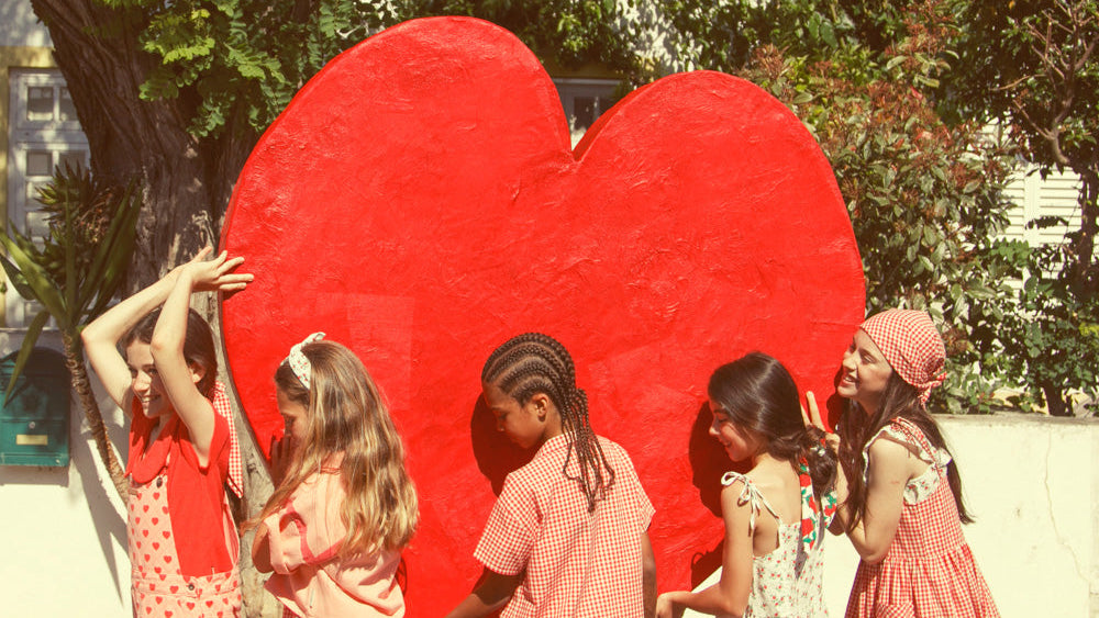 Grupo de niños cargando un corazón gigante