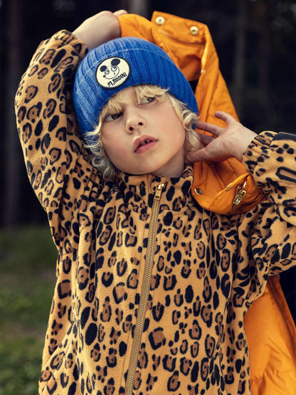 Modelo llevando chaqueta de niño beige leopardo de Mini Rodini.
