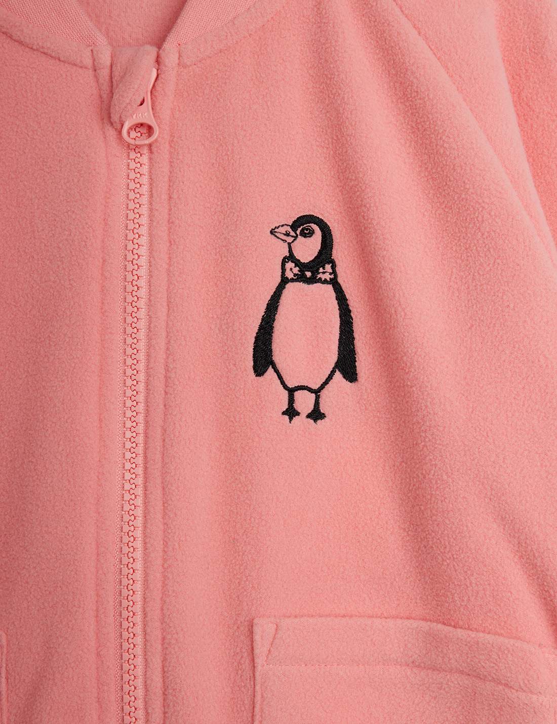 Detalle del diseño pingüino bordado en color rosa.