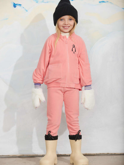 Modelo llevando chaqueta de niño rosa pingüino bordado de Mini Rodini.