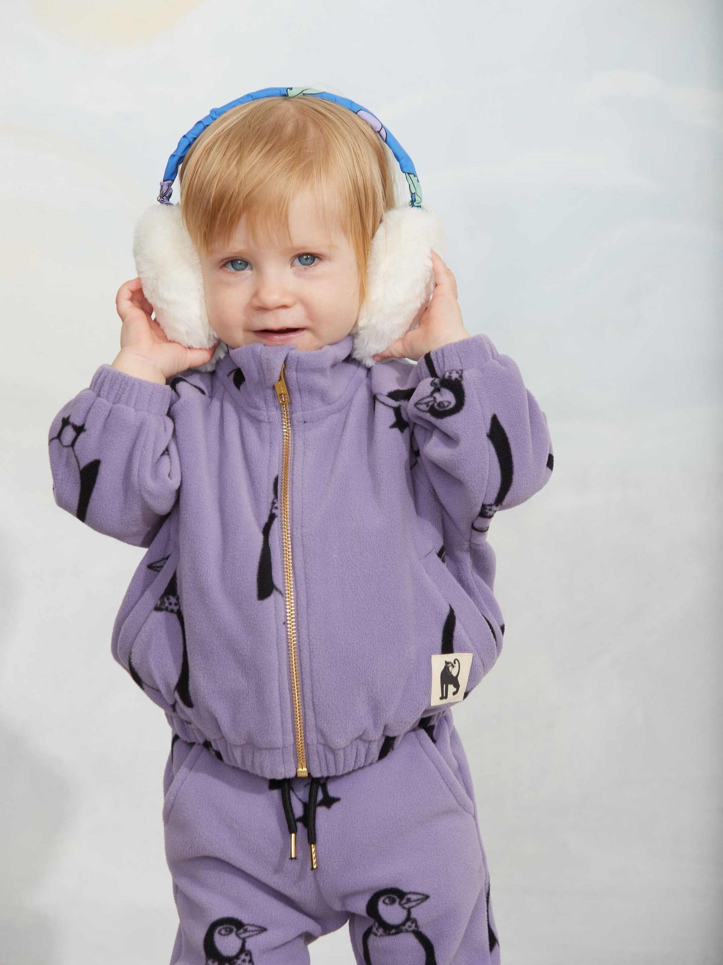 Modelo llevando chaqueta de niño púrpura pingüinos de Mini Rodini.