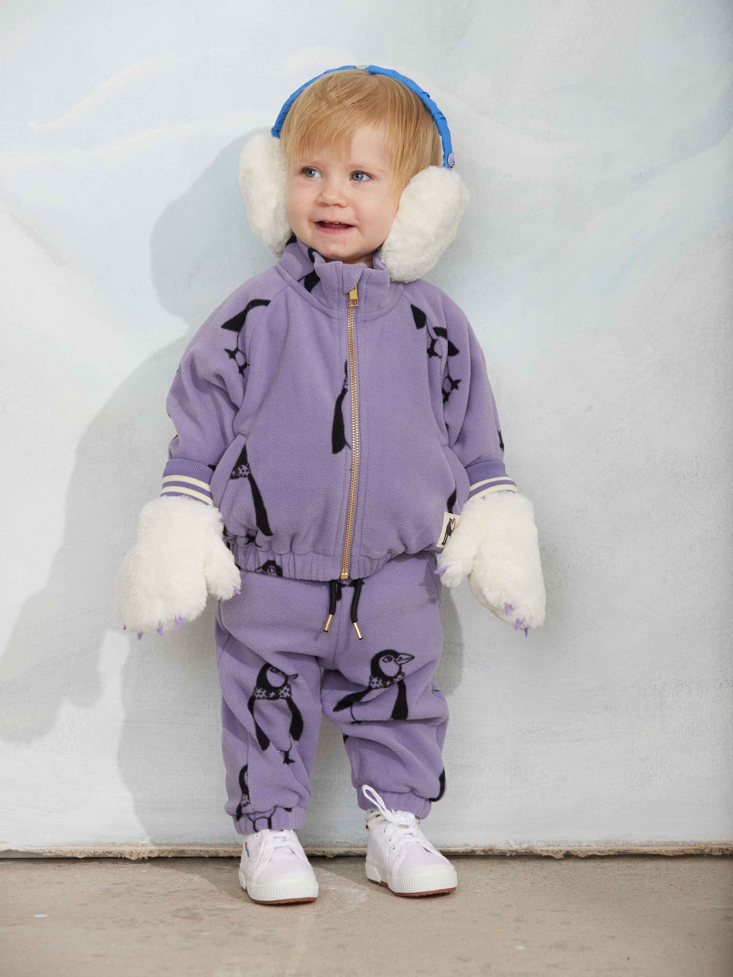 Modelo llevando chaqueta de niño púrpura pingüinos de Mini Rodini.