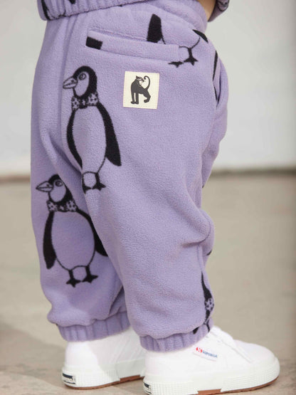 Modelo llevando pantalón de niño púrpura pingüinos de Mini Rodini.
