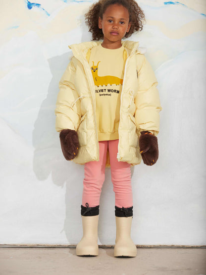 Modelo llevando sudadera de niño amarillo gusano velvet de Mini Rodini.