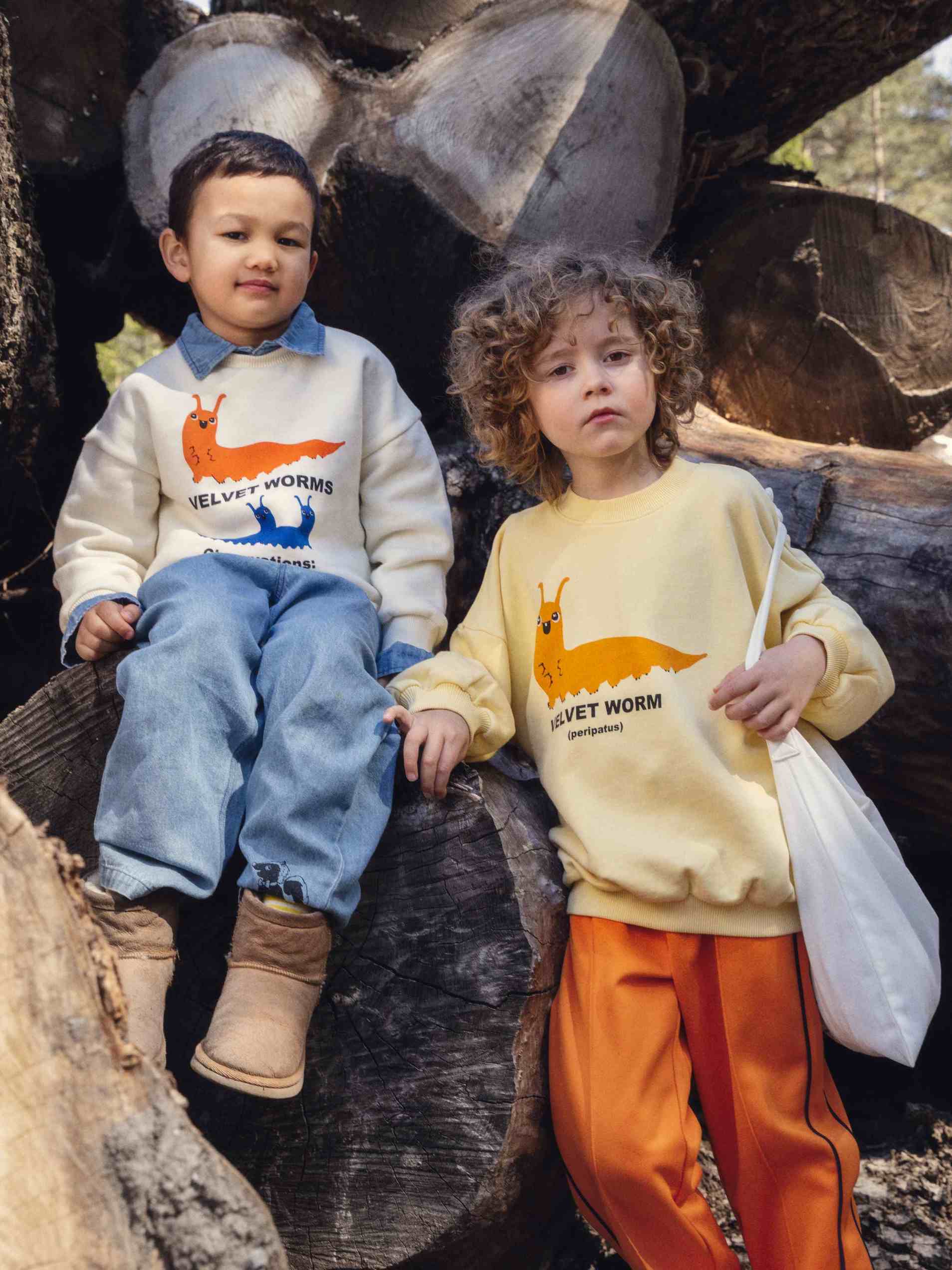 Modelo llevando sudadera de niño amarillo gusano velvet de Mini Rodini.