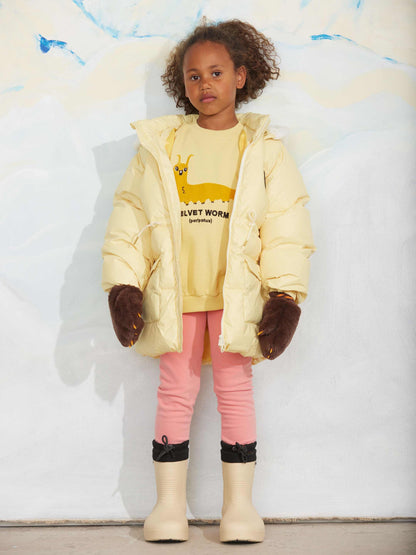Modelo llevando sudadera de niño amarillo gusano velvet de Mini Rodini.
