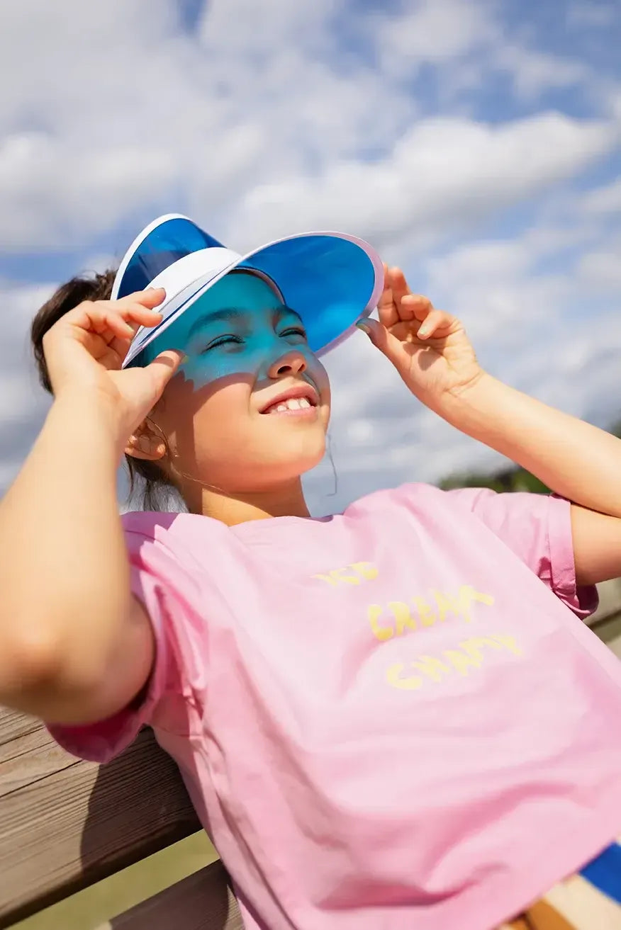 Niña con camiseta rosa Ice Cream Champ y gafas de sol.