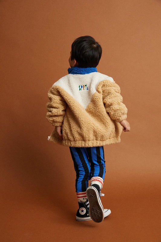 Persona posando con chaqueta de niño beige azul Bloques de Color de Sproet & Sprout.
