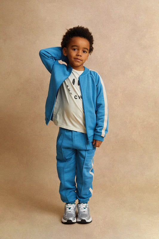 Persona posando con pantalón de niño azul oscuro Deportivo de Sproet & Sprout.