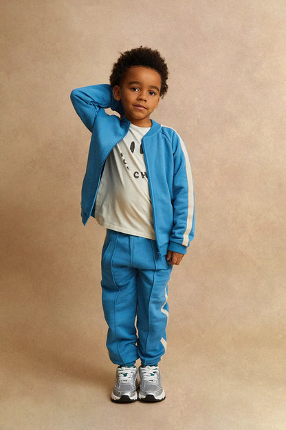 Persona posando con pantalón de niño azul oscuro Deportivo de Sproet & Sprout.