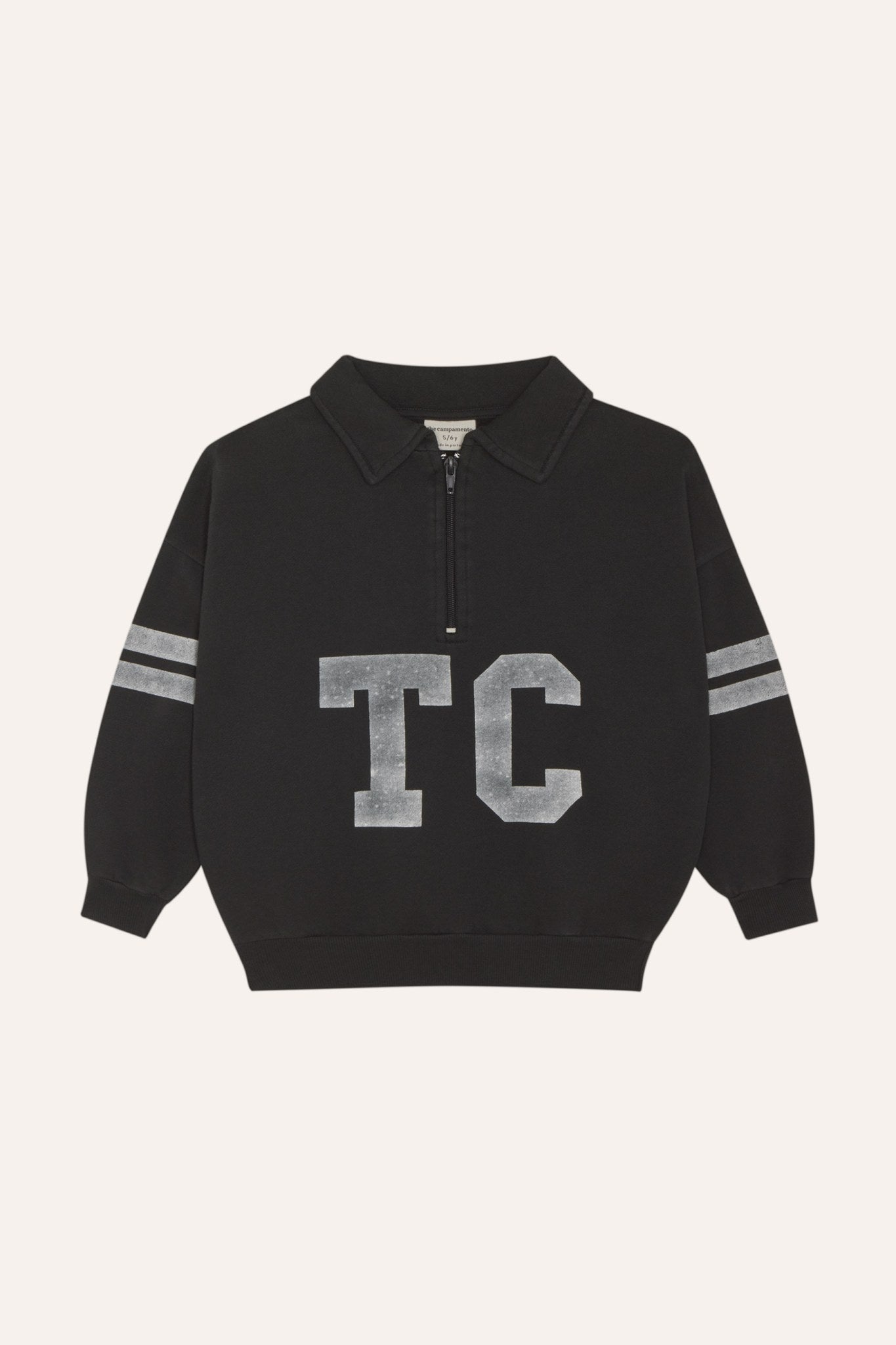 Sudadera gris oscuro con cuello abierto, letras TC y bandas, vista frontal.