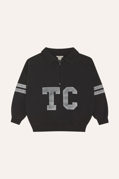 Sudadera gris oscuro con cuello abierto, letras TC y bandas, vista frontal.