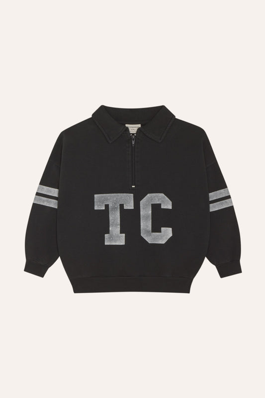 Sudadera gris oscuro con cuello abierto, letras TC y bandas, vista frontal.