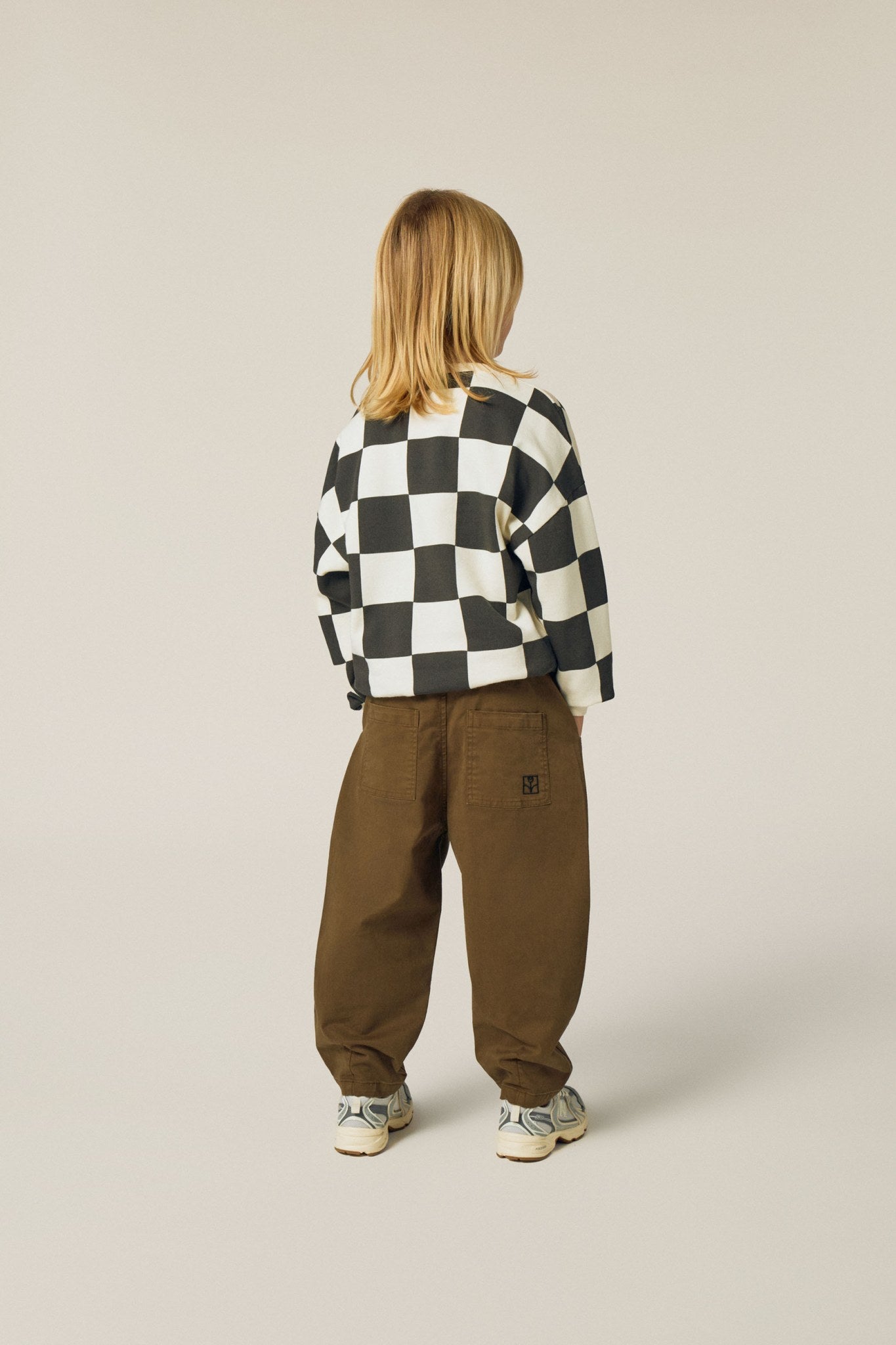 Niña de espaldas con la sudadera de cuadros.