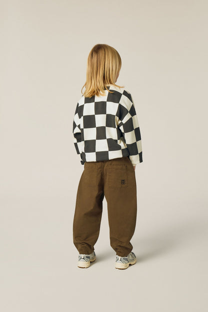 Niña de espaldas con la sudadera de cuadros.