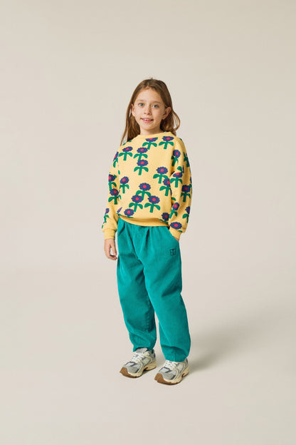 Niña posando de frente con la sudadera amarilla de margaritas.