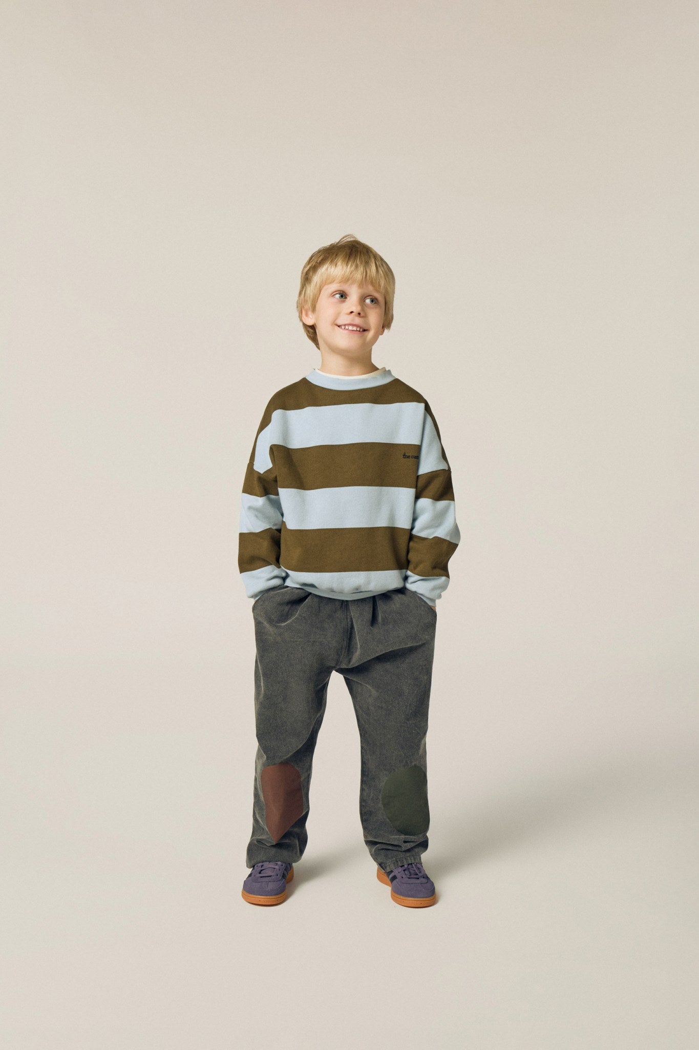 Niño posando de frente con la sudadera de rayas anchas.