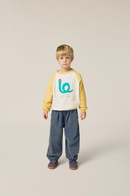 Niño posando de frente con la sudadera cruda de serpiente.
