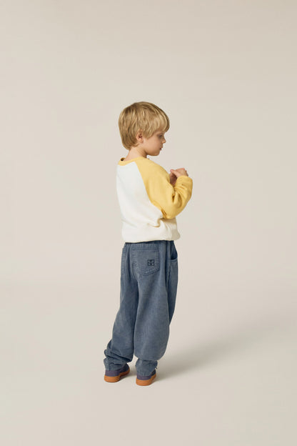 Niño de perfil con la sudadera cruda de serpiente.