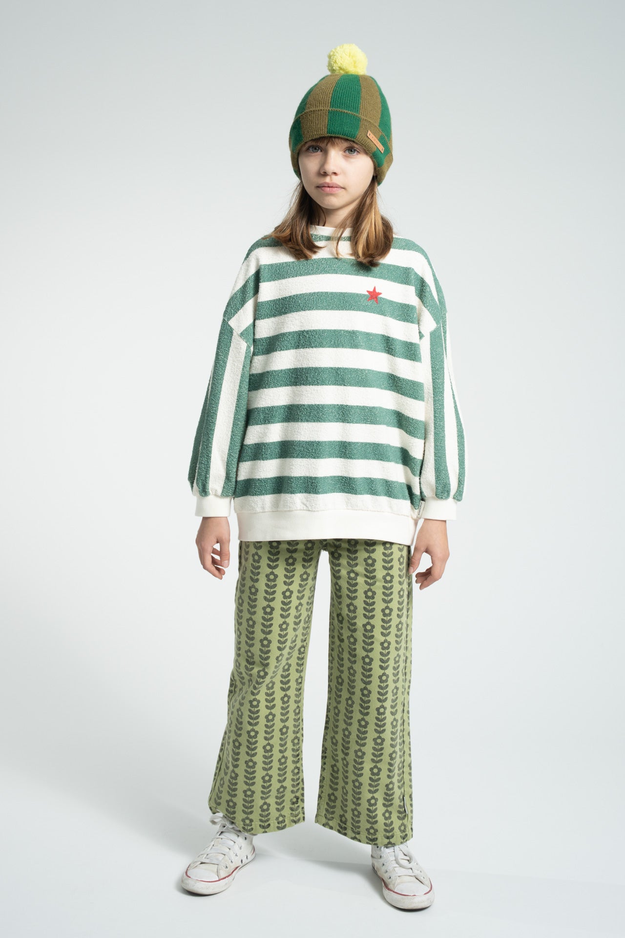 Parte trasera de pantalón acampanado de niña verde con flores negras de piupiuchick.