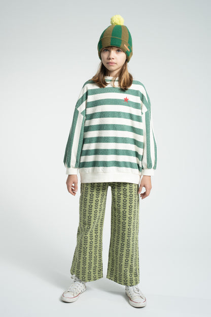 Parte trasera de pantalón acampanado de niña verde con flores negras de piupiuchick.